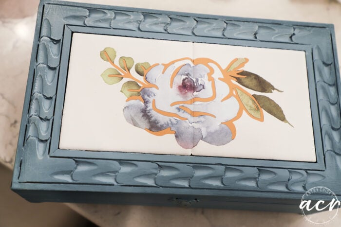 blue box with gold dry brushed onto it with blue floral on tiles