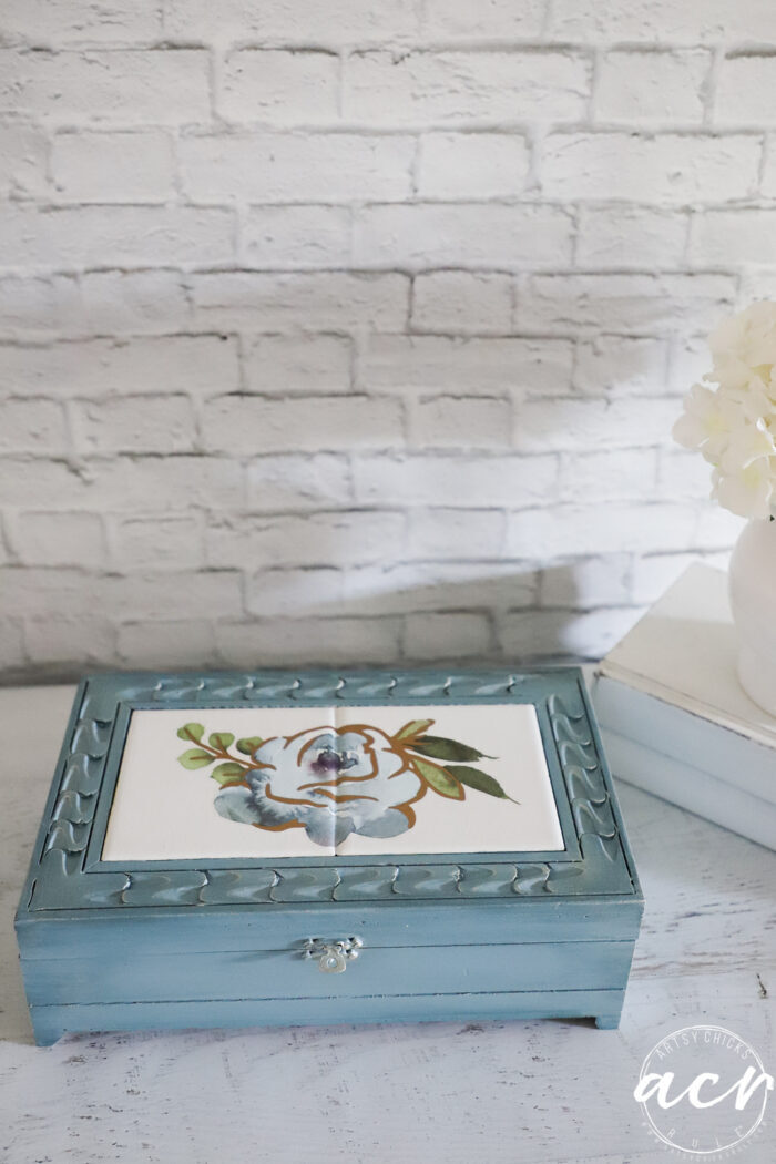 top view of blue box with blue flower on white table