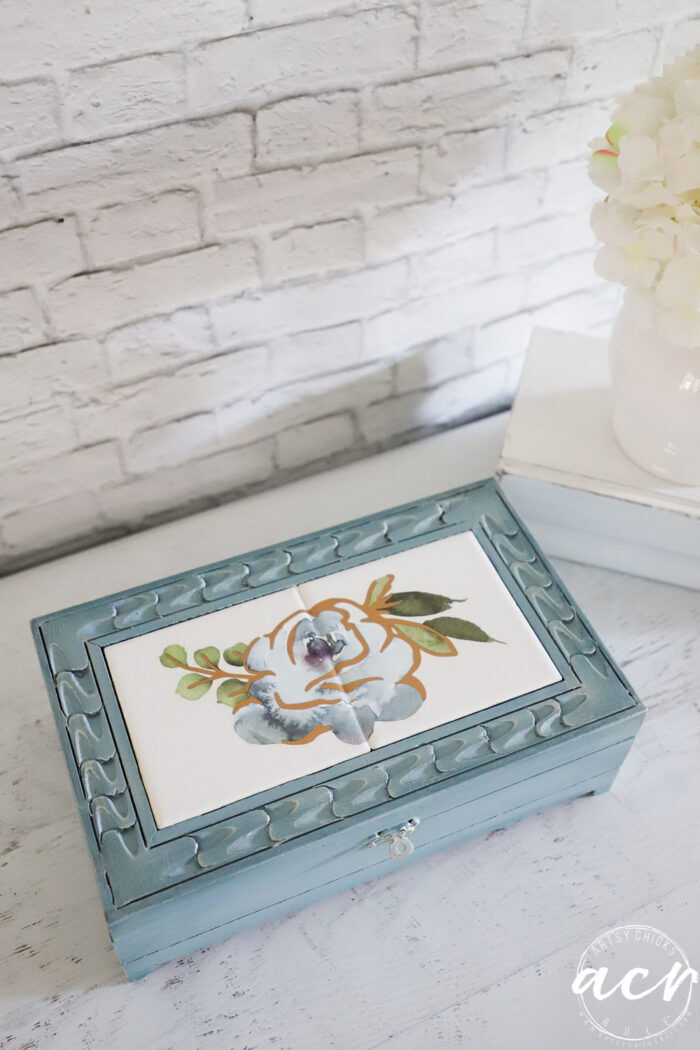 top view of blue box with white tiles and blue flower