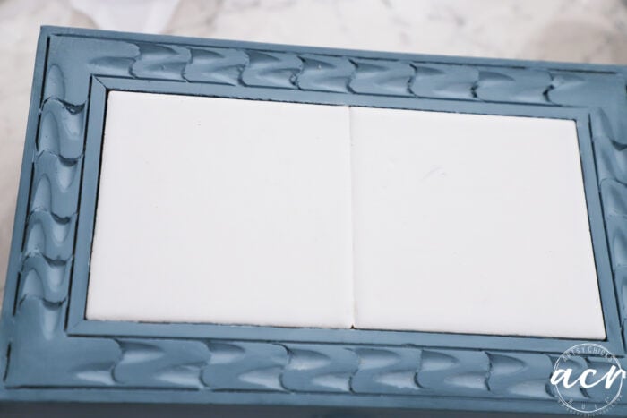 blue painted box with wood decor on top and white tiles