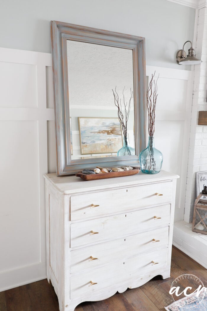 white dresser with blue mirror and aqua vase wood bowl