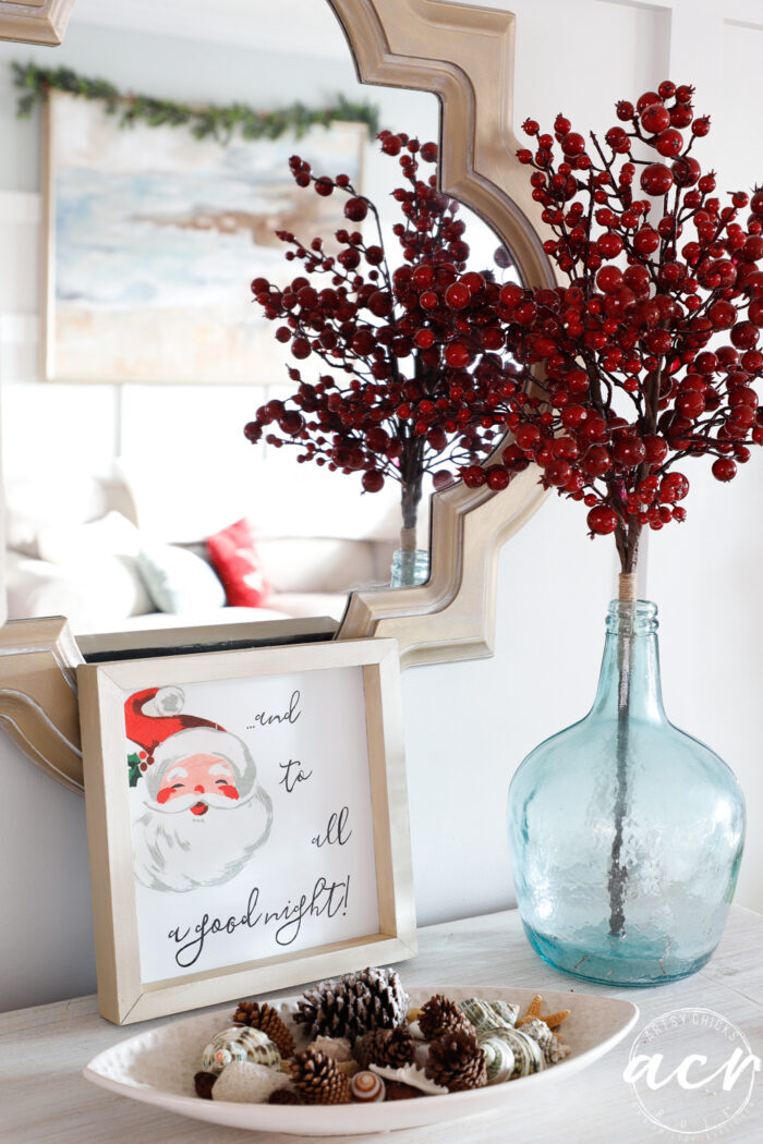 santa sign with pine cones and blue vase with red berries