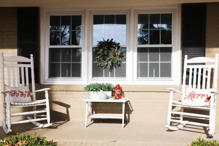 white rockers with christmas pillows and green wreath on window