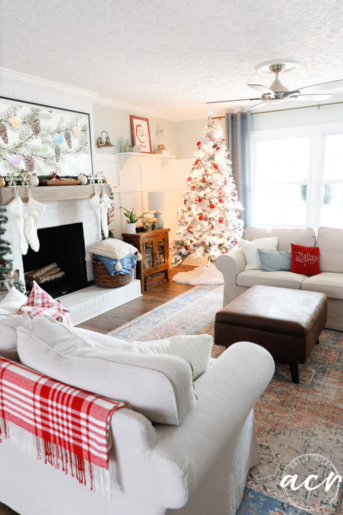 living room shot with tree, fireplace and tan furnitur