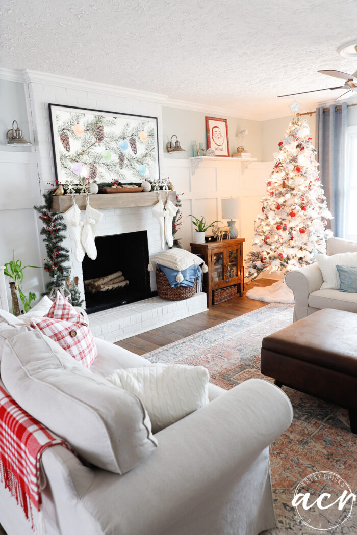 living room with fireplace and red decor christmas tree tan furniture