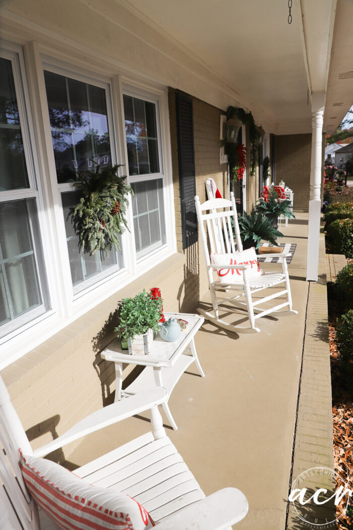 looking down porch with white rockers and christmas decor