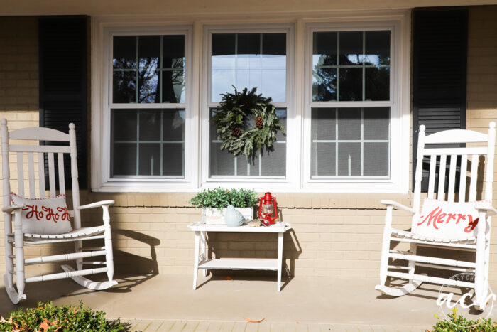white rockers with christmas pillows and green wreath on window
