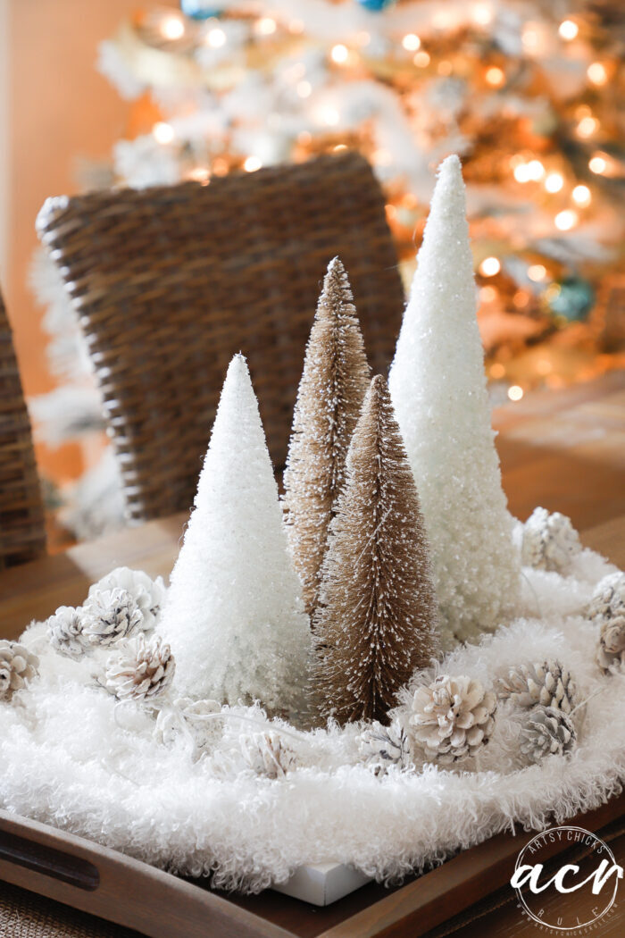 gold and white christmas trees with white furry "snow" around them