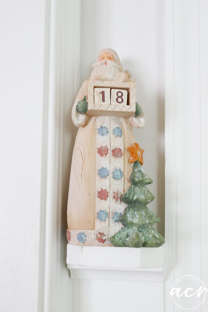 santa figurine on ledge holding numbers