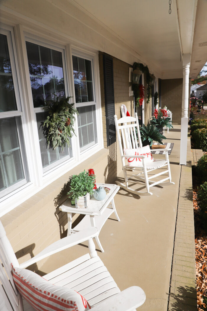 looking down porch with white rockers and christmas decor