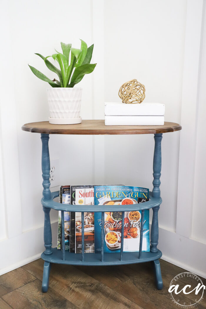 blue table with plant and white books and magazines below