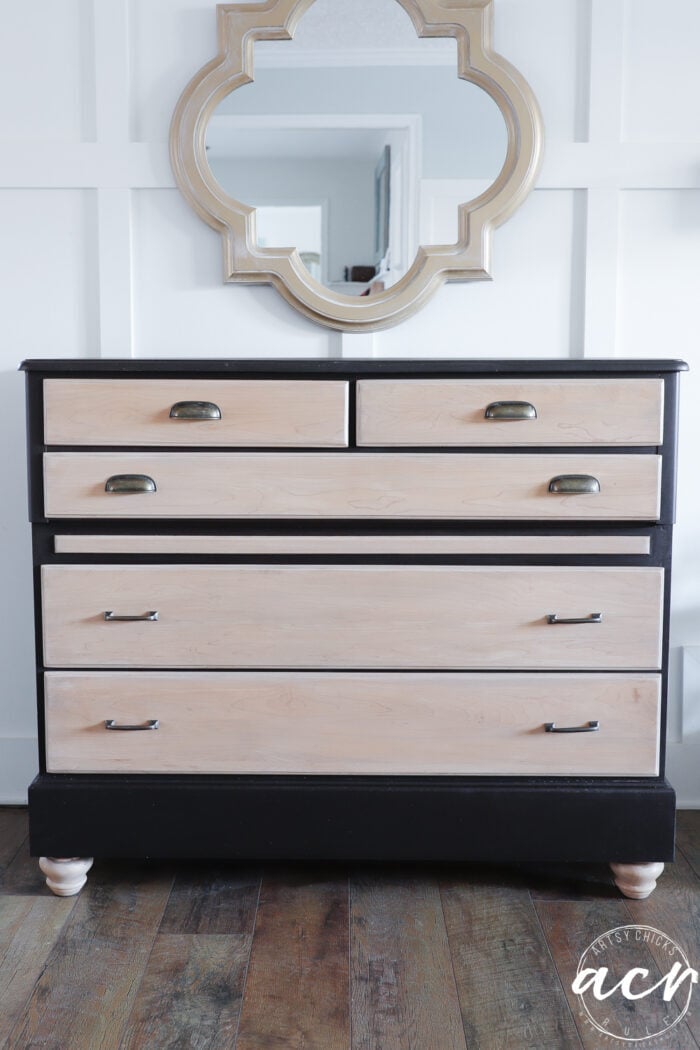 two tone dresser with gold mirror and white wall
