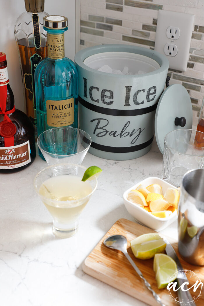 ice bucket with ice on counter with cocktail fixings