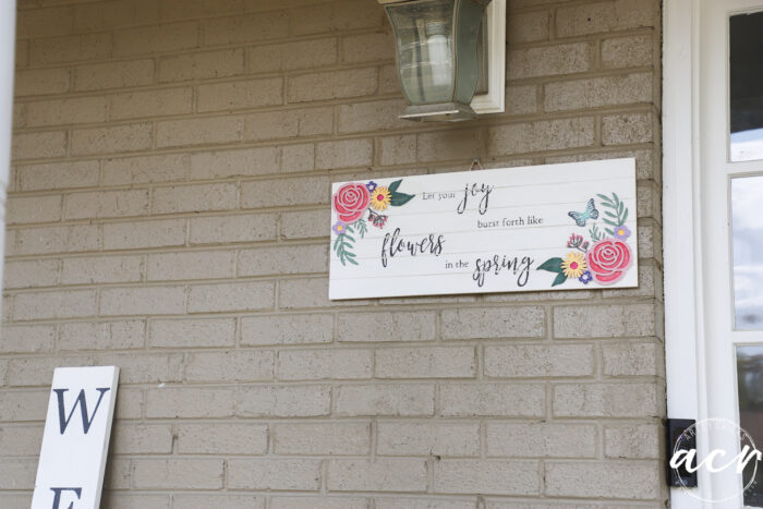 spring sign hanging on exterior brick