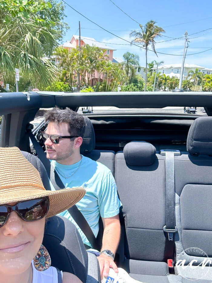 lady in hat and young man in back of convertible