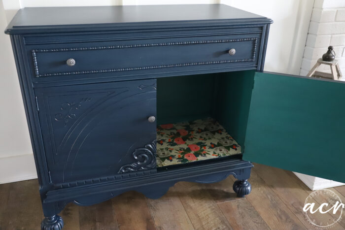 blue cabinet with one door open, flower decoupage on base