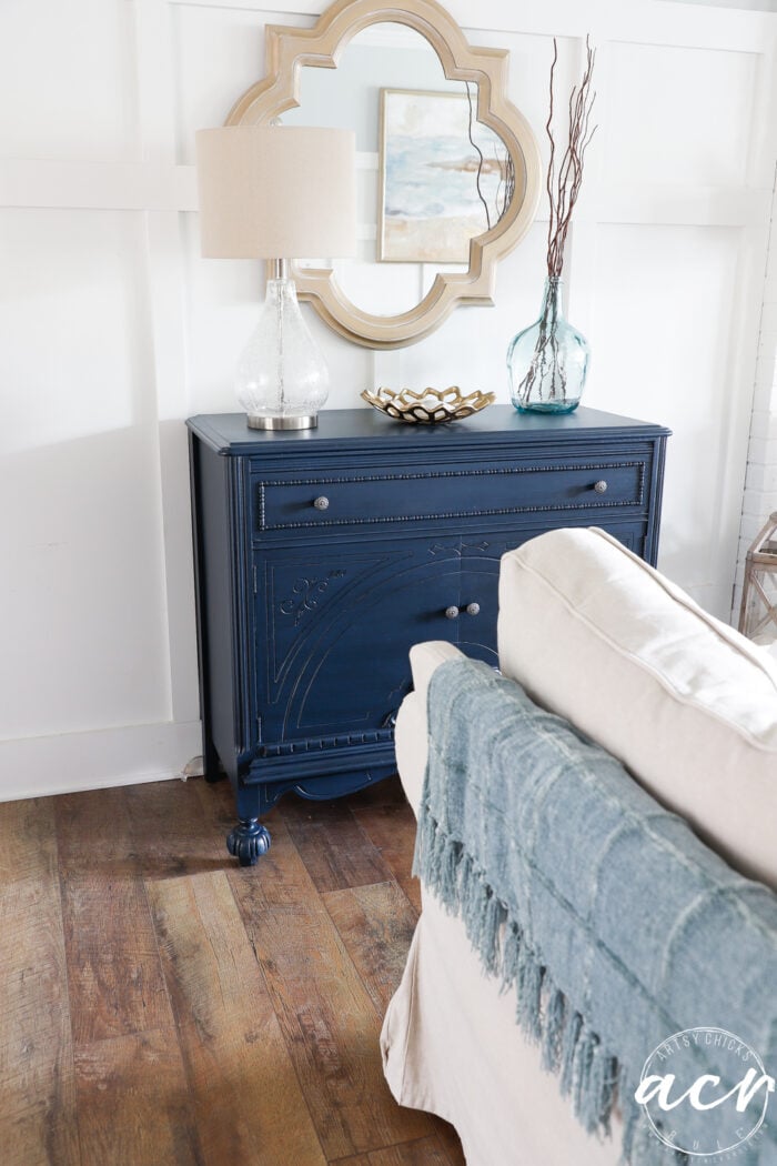 blue cabinet decorated with tan couch in room