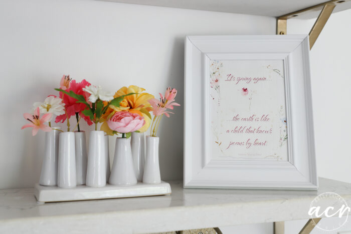 printable in white frame on shelf with colorful flowers beside