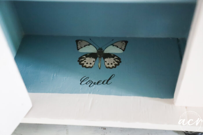butterfly and script,loved, on bottom shelf 