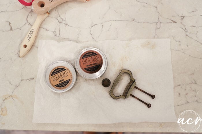 containers of gilder's paste and hardware on counter