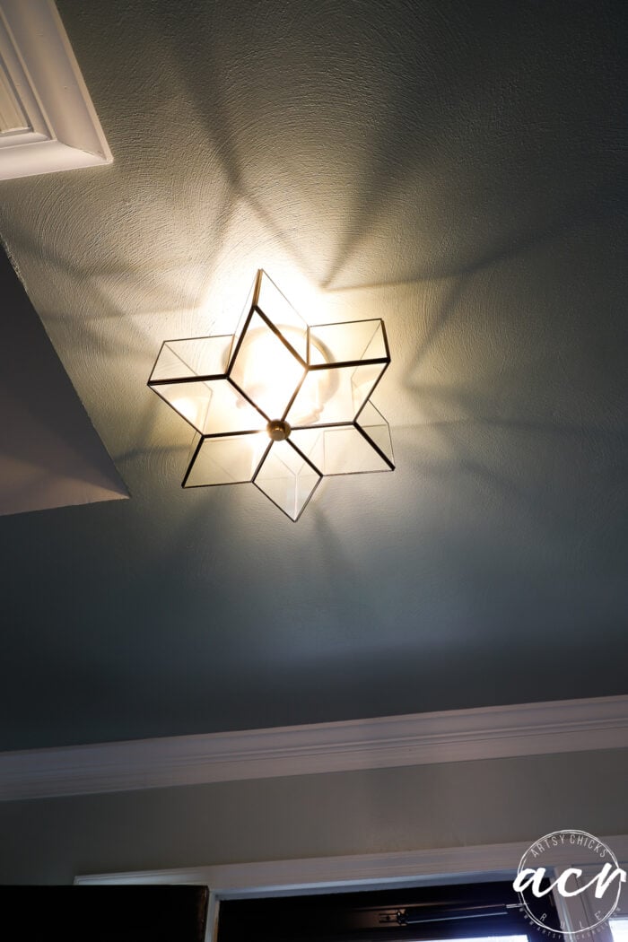 star shaped light fixture with light on and star reflection on ceiling