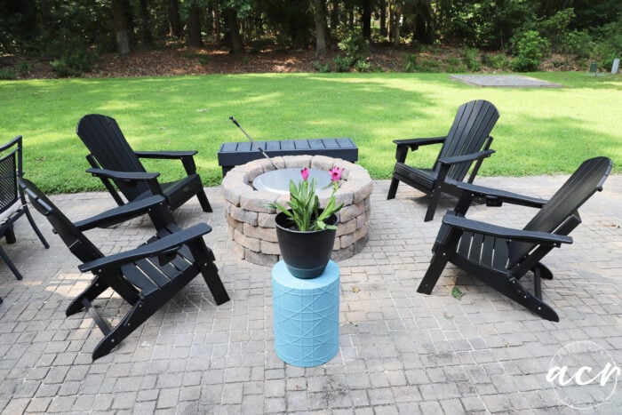 black adirondack chairs around a firepit on patio