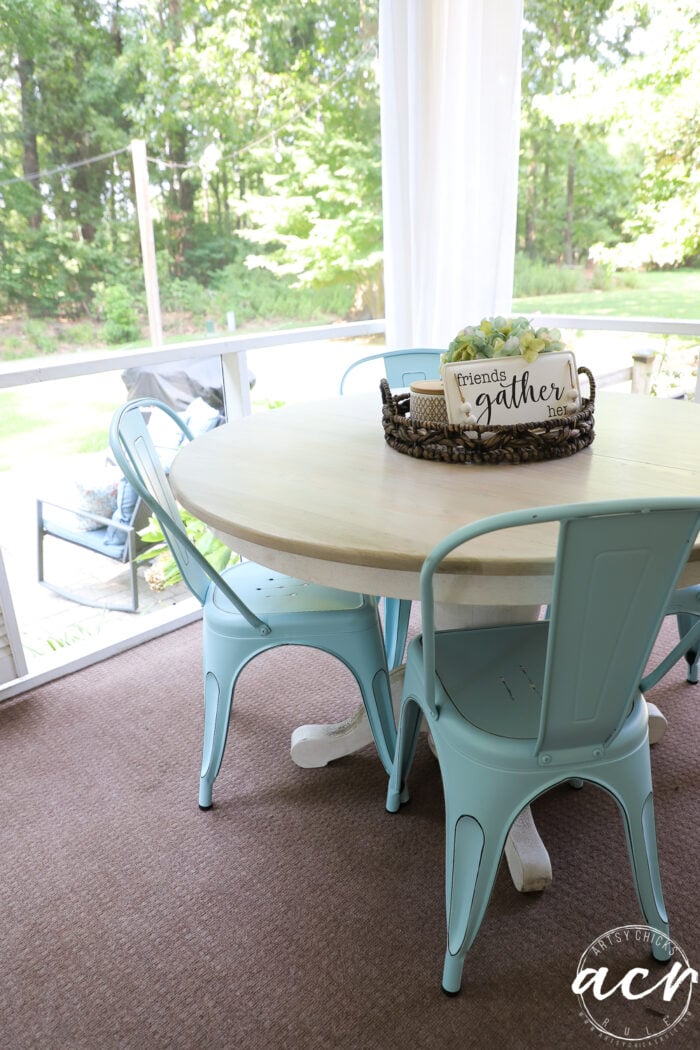 wood table with aqua colored metal chairs