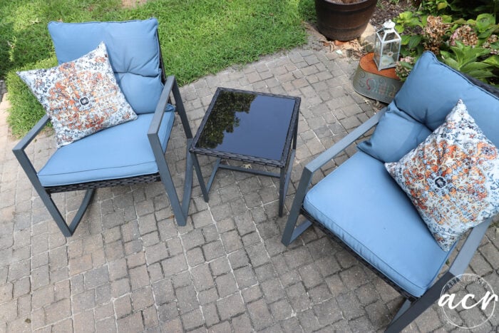 blue cushioned black rocker chairs with glass topped table