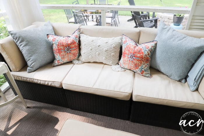 tan and brown couch with blue white and orange pillows