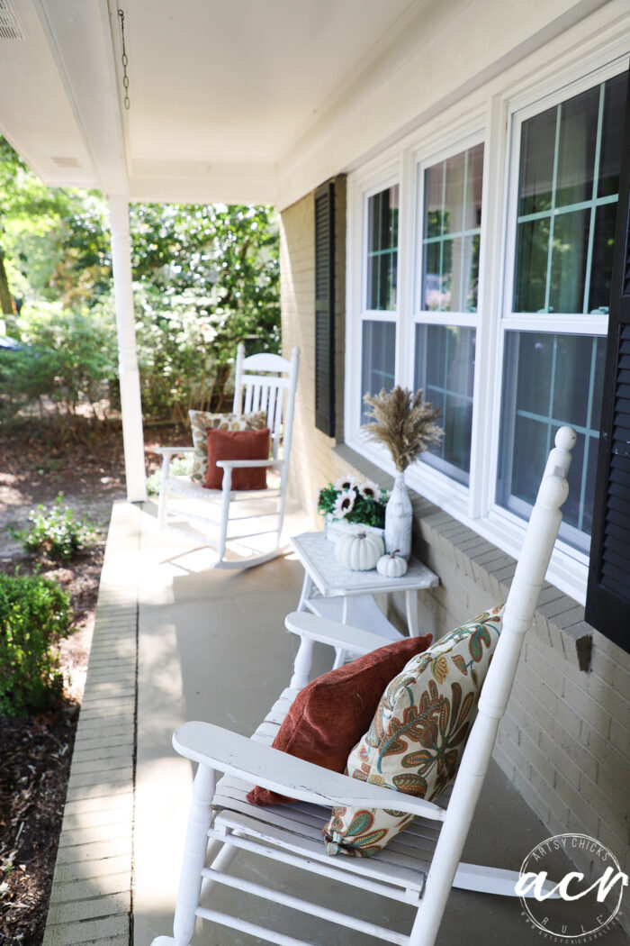 white rockers on front porch with rust pillows