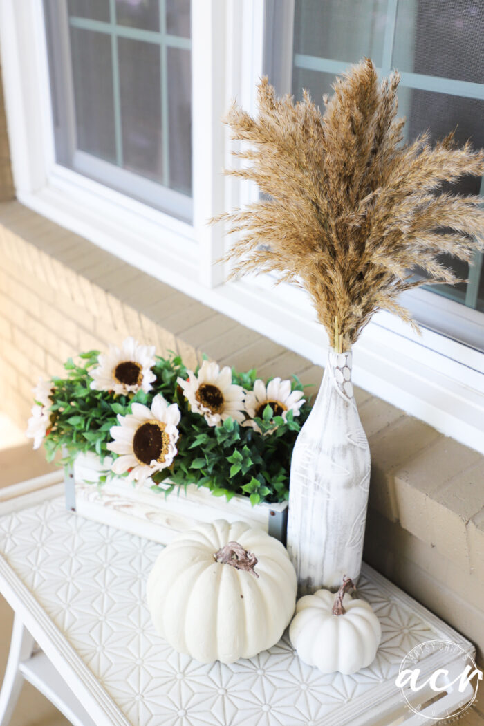 wood vase with dried grass, ivory pumpkins and sunflowers
