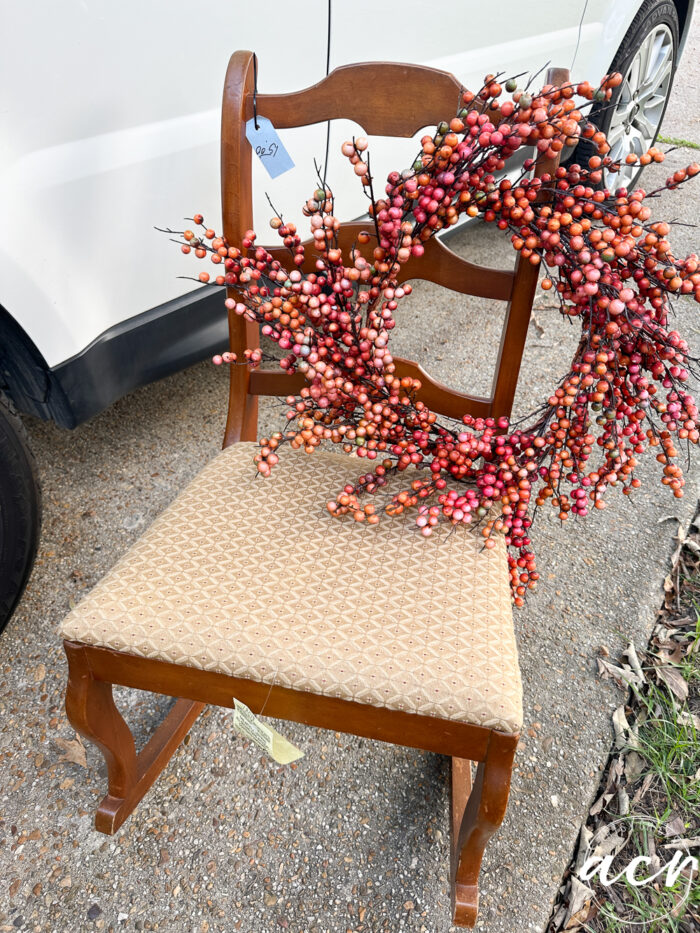 wood rocker with orange wreath hanging on back