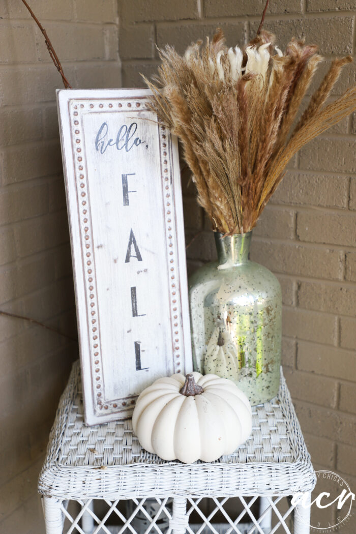 white wicker table with pumkin and hello fall sign
