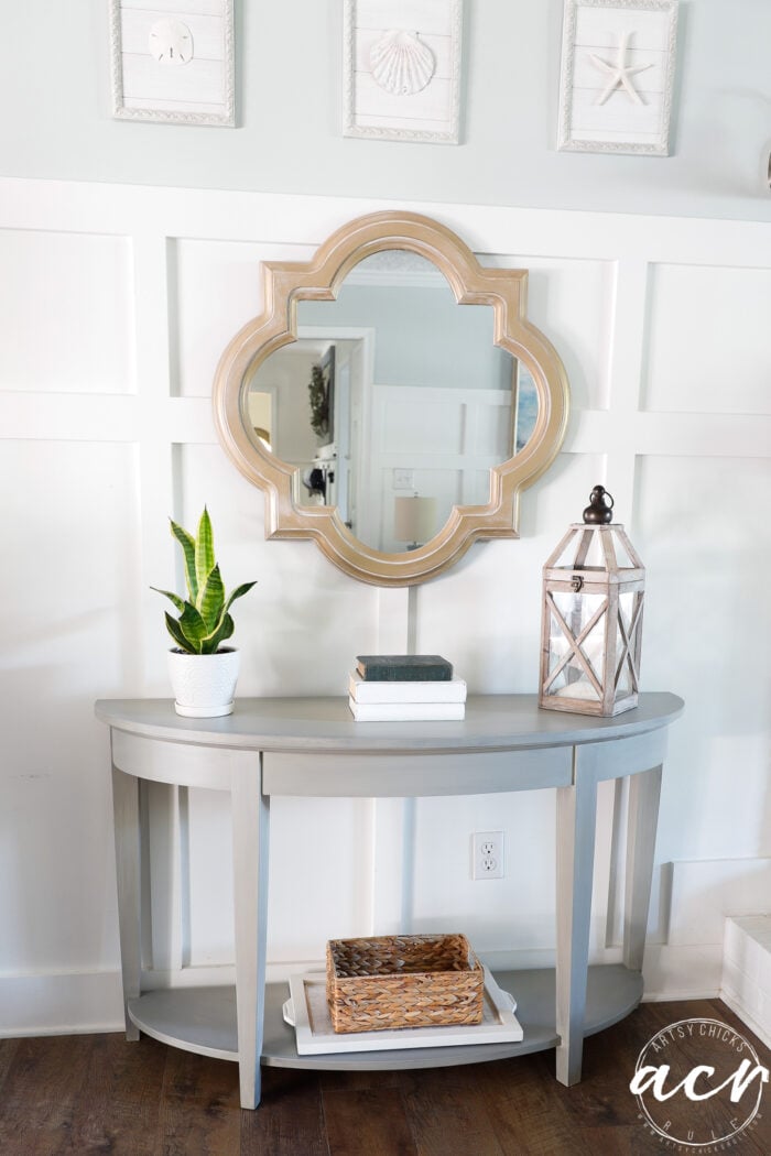 console table styled with gold mirror over top