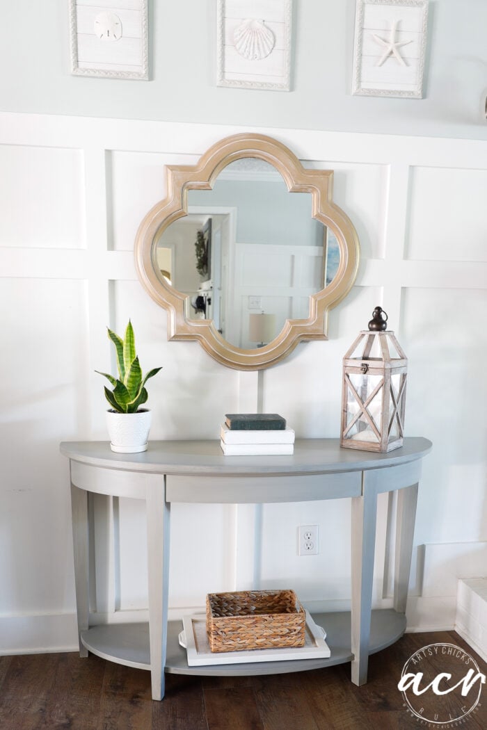 console table styled with gold mirror over top