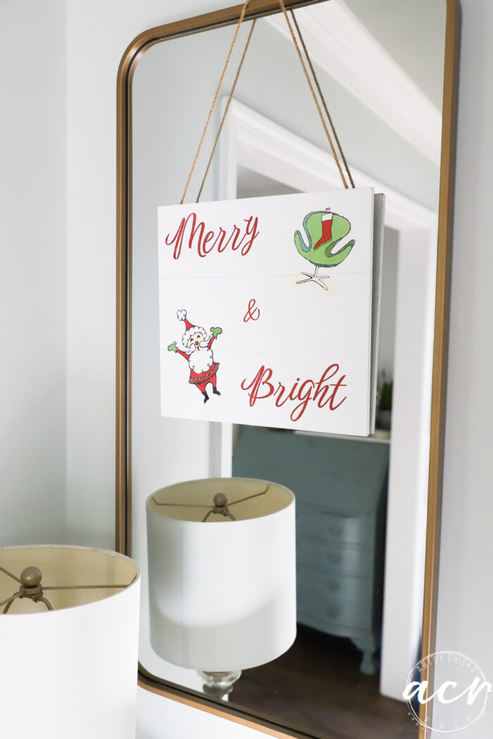 merry and bright sign hanging on gold mirror