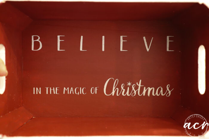 inside of box painted red with the words "believe in the magic of Christmas"