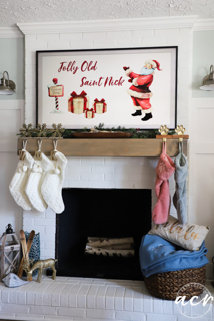 tv over mantel with stockings with santa sign on tv