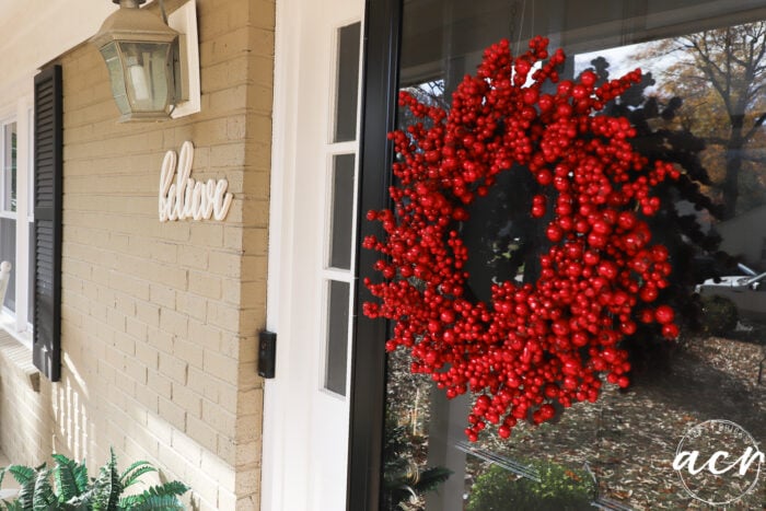 front door with red berry wreath