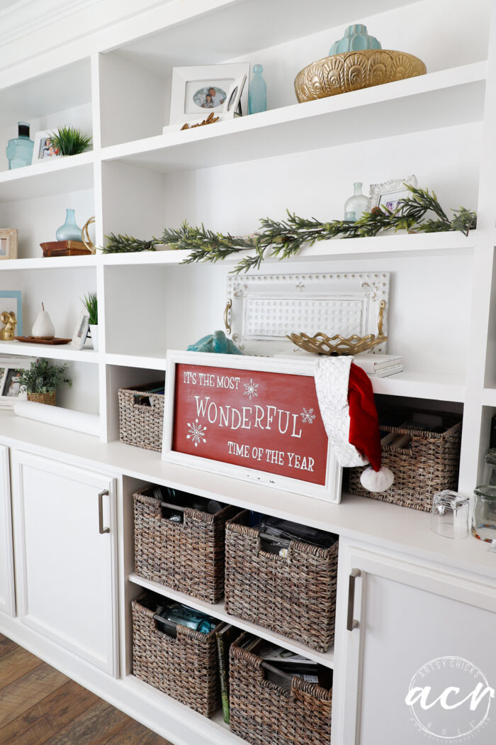bookcases with decor, baskets and the most wonderful time of the year sign