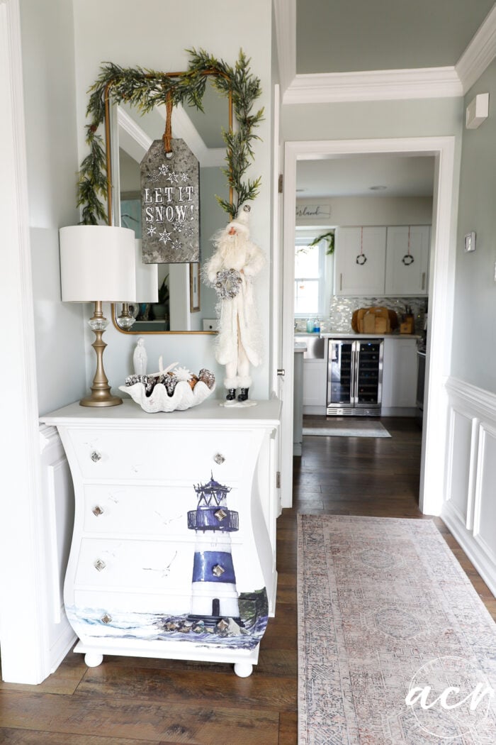 small white chest with mirror over in foyer
