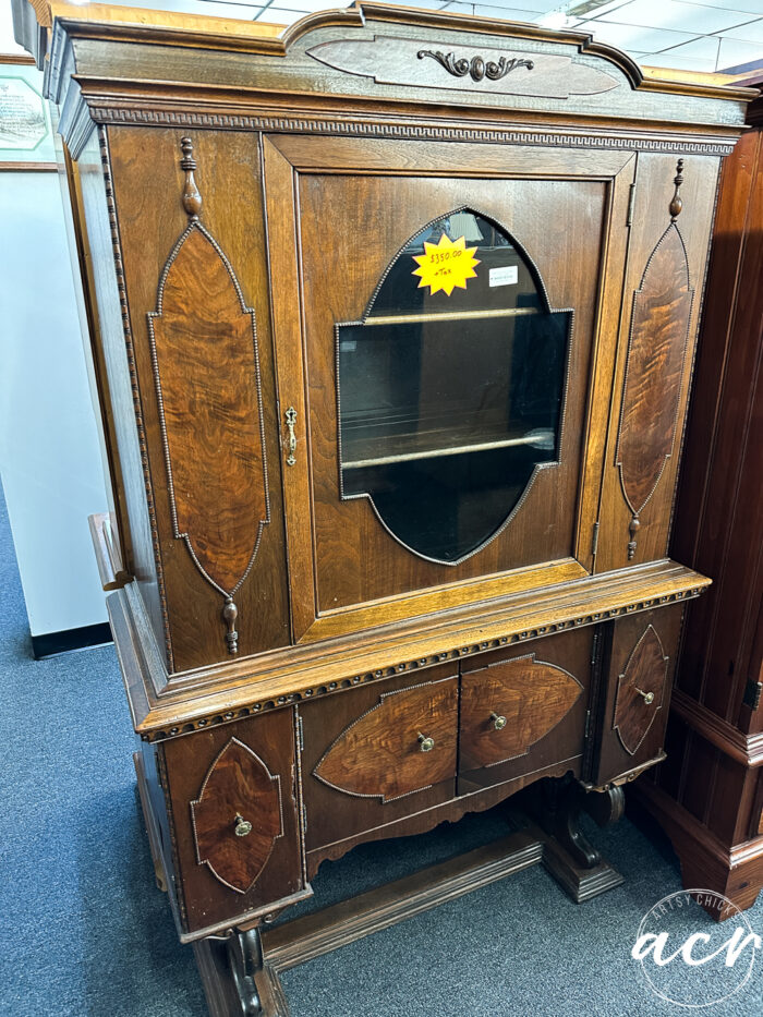 wood ornate cabinet with glass center area door