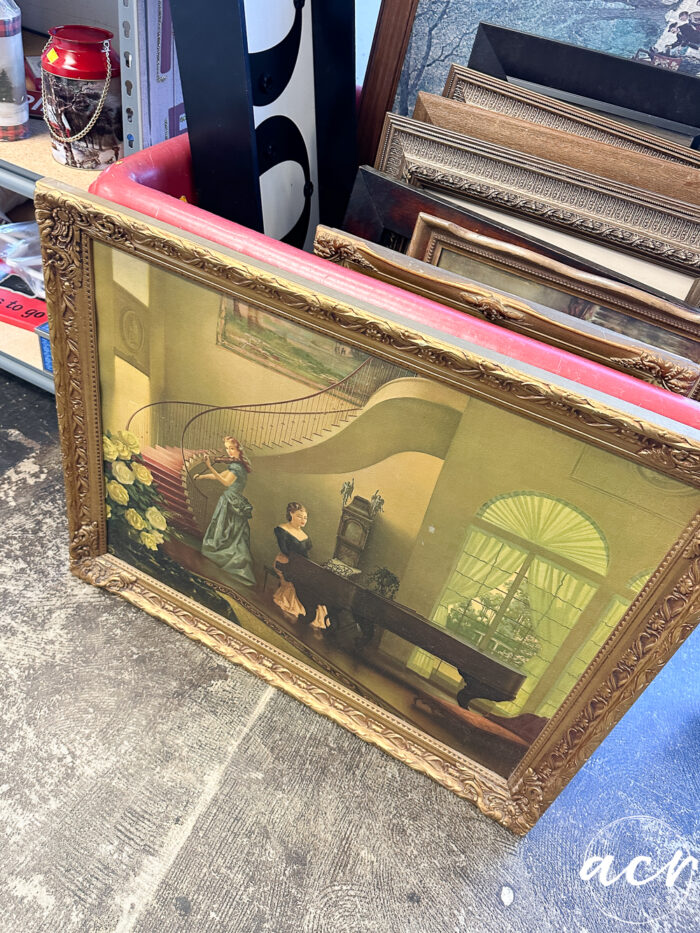 old gold frame print of girl playing piano and girl playing violin