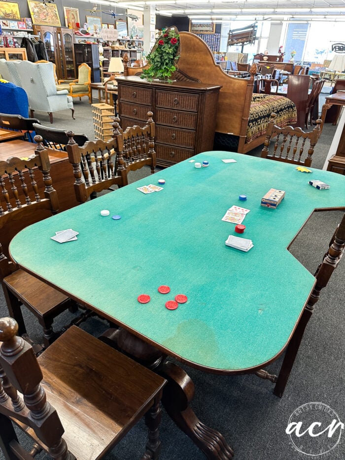 poker table with green felt top and wood chairs