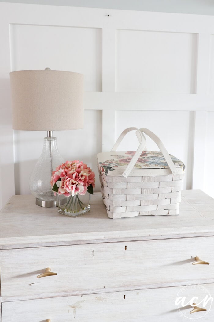 white basket with floral transfer on dresser with lamp