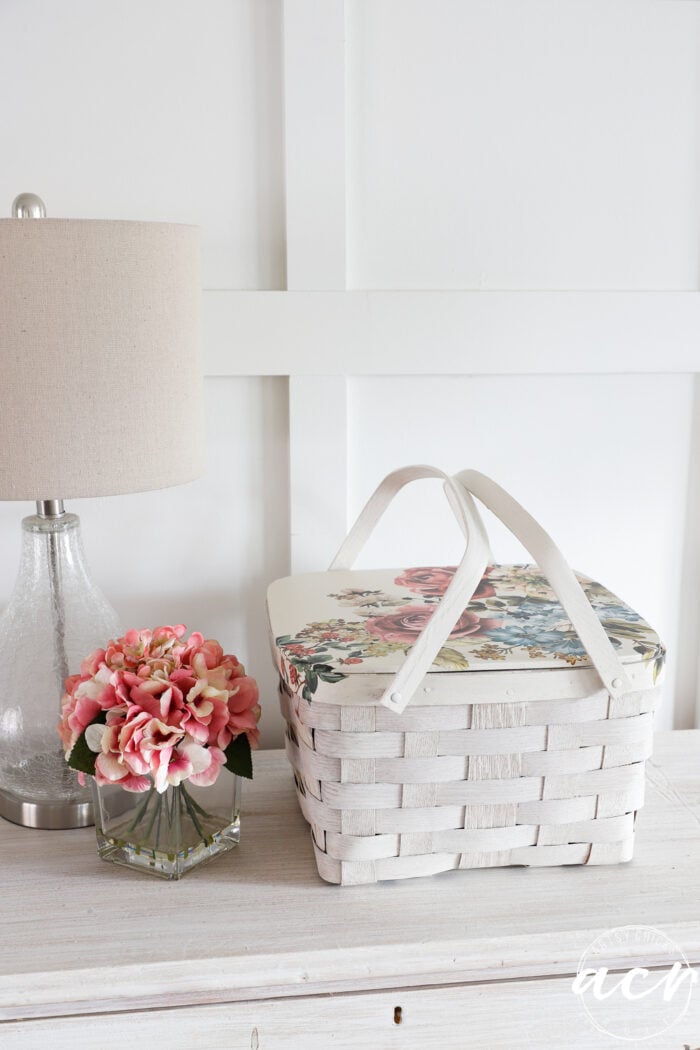 white basket with floral transfer on dresser with lamp