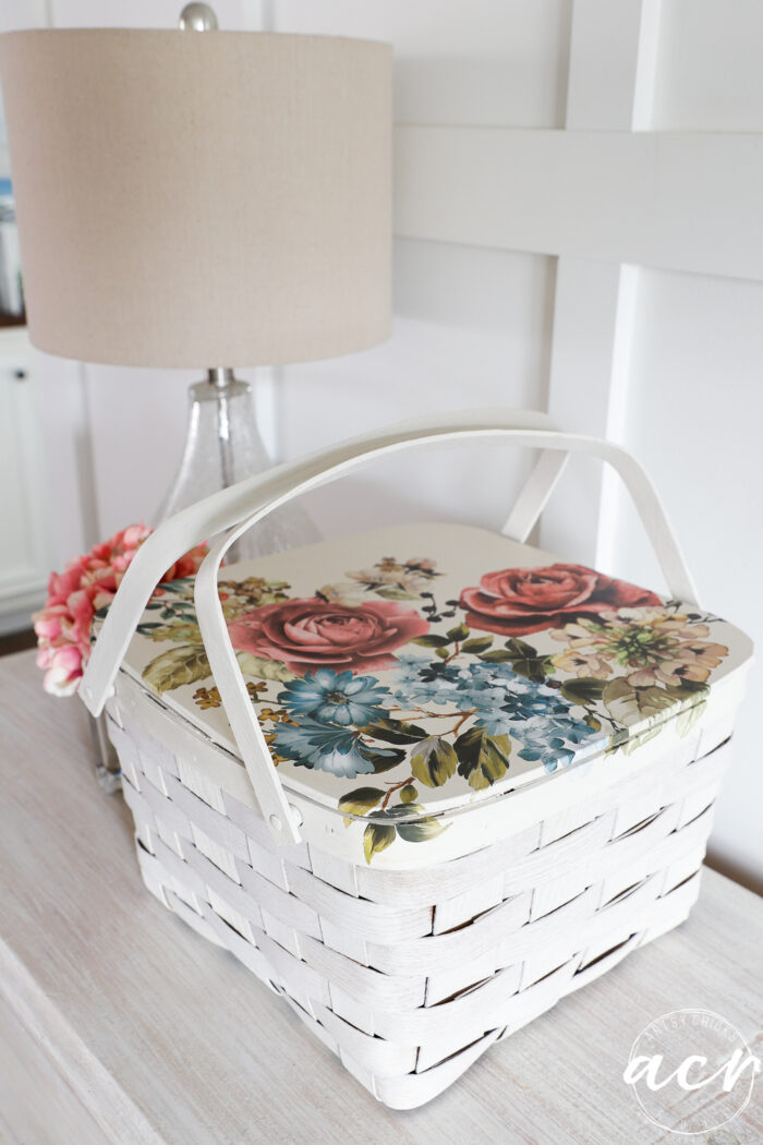 white basket with floral transfer on dresser with lamp