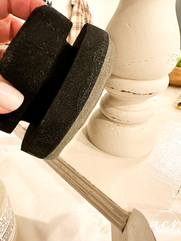 black sponge applying topcoat to table leg