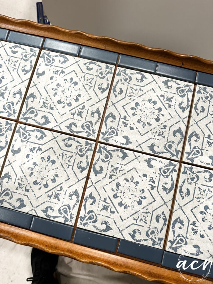 decorative white and blue tiles with navy blue tiles on the edges of table top