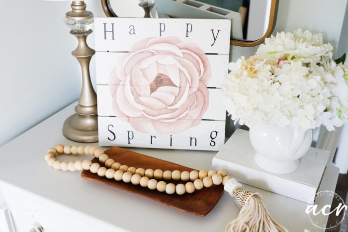 happy spring sign on top of chest with decor